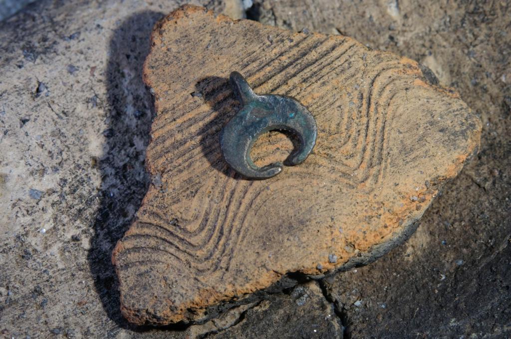 Ozdoba i fragment ceramiki odkryty w czasie wykopalisk