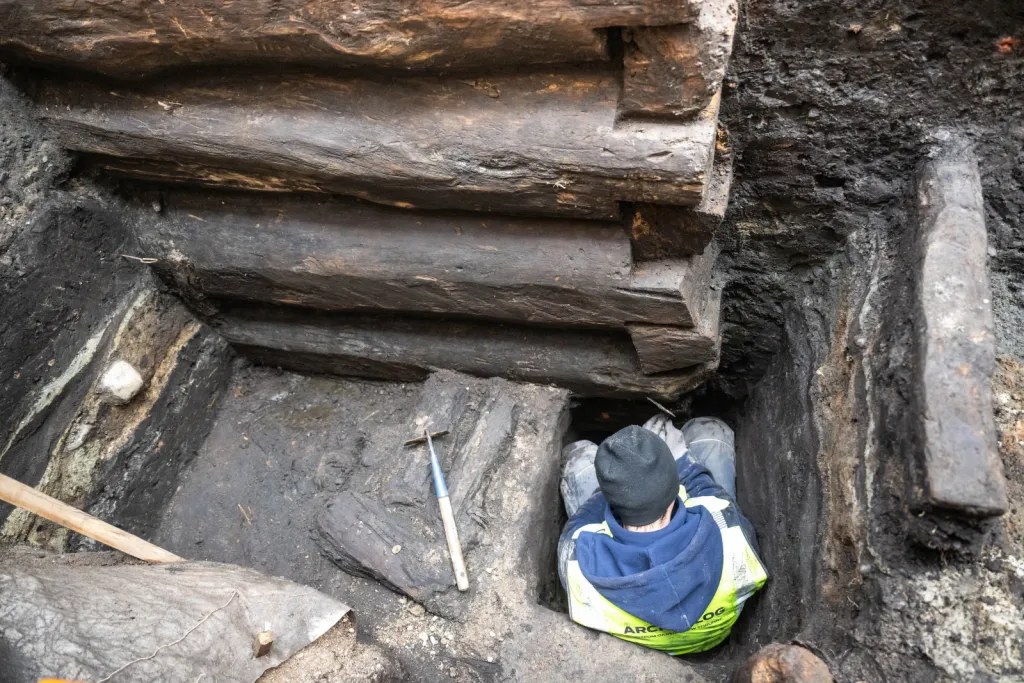 Toruń, 19.11.2025. Fragment nieznanych wcześniej drewnianych konstrukcji z XIII wieku, 19 bm. w Toruniu. Konstrukcje odkryte zostały podczas badań archelogocznych na dziedzińcu Domu Mikołaja Kopernika w Toruniu. To jedne z najstarszych takich znalezisk w mieście. Konstrukcje trafią do konserwacji i staną się elementem przyszłej wystawy stałej muzeum. (mr) PAP/Tytus Żmijewski