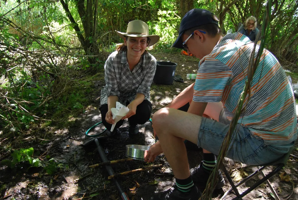 Studenci Wydziału Archeologii UW w trakcie płukania ziemi z wypełnisk pieców dymarskich. Na sitach laboratoryjnych znajdywane są zwęglone szczątki nasion i owoców roślin  – cenne źródła do badań archeobotanicznych. Fot. A. Cieśliński