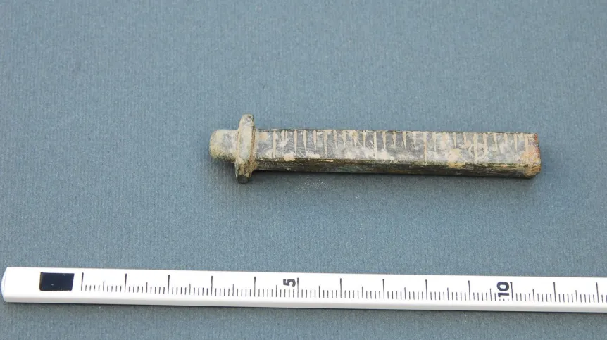 Fragment wagi z brązu znaleziony w domniemanej aptece. Fot. J. Reclaw 



