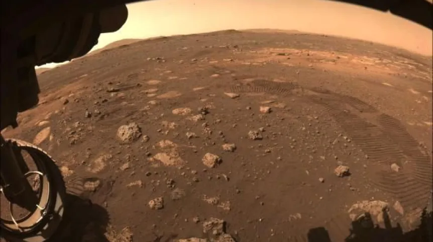 Zdjęcie wykonane 4 marca 2021 r. podczas pierwszej jazdy łazika Perseverance po Marsie. Widać pozostawione ślady kół. Źródło: NASA/JPL-Caltech.