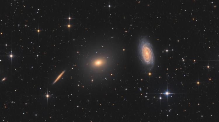 The image shows the elliptical galaxy NGC 5982 (centre) and the spiral galaxy NGC 5985 (right). It turns out that these two types of galaxies behave differently when there is excess gravity in their outer regions. Credit: Bart Delsaert (www.delsaert.com).