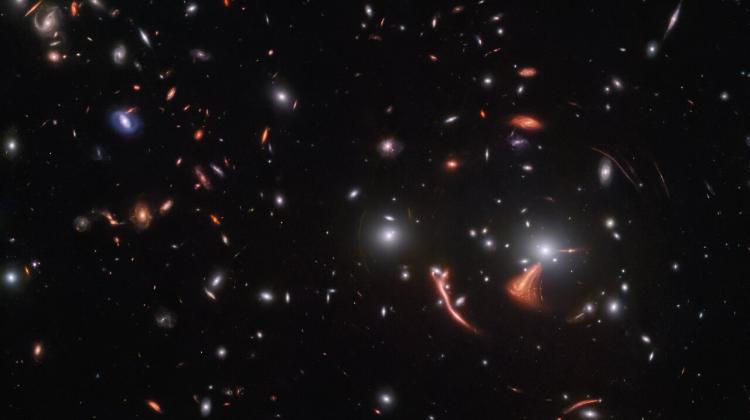 Soczekowanie grawitacyjne odległych galaktyk przez gromadę galaktyk SDSS J1226+2149. Obraz uzyskano przy pomocy Kosmicznego Teleskopu Jamesa Webba. Źródło: ESA/Webb, NASA & CSA, J. Rigby.