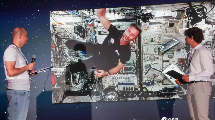 Łódź, 02.07.2025. Przebywający na Międzynarodowej Stacji Kosmicznej polski astronauta Sławosz Uznański-Wiśniewski (na ekranie) podczas połączenia wideo na żywo w EC1 w Łodzi, 2 bm. Podczas trwającego ok. 20 minut połączenia Sławosz Uznański-Wiśniewski wykonywał eksperymenty w stanie nieważkości oraz odpowiadał na pytania zadawane przez młodzież. (jm) PAP/Marian Zubrzycki