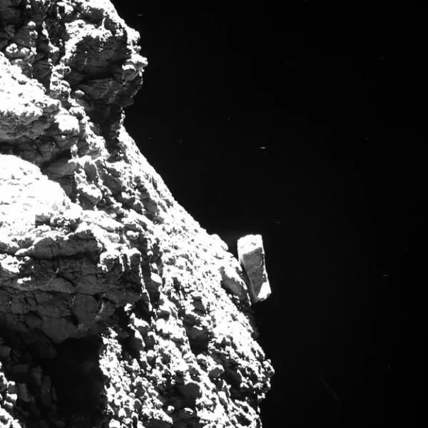 Fragment komety 67P/Churyumov-Gerasimenko. Przy lewym brzegu zdjęcia można dostrzec element lądownika Philae. Skala zdjęcia to 4,6 cm/piksel. Źródło: ESA/Rosetta/MPS for OSIRIS Team MPS/UPD/LAM/IAA/SSO/INTA/UPM/DASP/IDA – CC BY-SA 4.0 