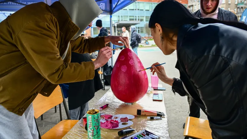 Szczecin, 26.03.2026. Uczestnicy konkursu malowania betonowych pisanek przed gmachem Wydziału Budownictwa i Inżynierii Środowiska Zachodniopomorskiego Uniwersytetu Technologicznego w Szczecinie. PAP/Marcin Bielecki